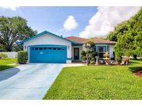 Charming single-story home with a well-maintained lawn, blue trim, and a blue driveway for added curb appeal at 2334 W Doris St, Kissimmee, FL 34741