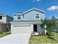 Charming two-story home with blue accents, a two-car garage, and a well-maintained front yard at 2739 San Marco Way, Winter Haven, FL 33884