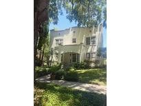 Elegant stucco home featuring a red tile roof, lush greenery, and a welcoming entrance with ample natural light at 501 Richmond St, Orlando, FL 32806
