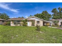 Charming single-story home with a well-manicured lawn and covered carport, perfect for suburban living at 830 N Sunset Dr, Mount Dora, FL 32757