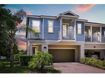 Charming two-story home with a blue exterior, balcony, and attached garage at 995 Grand Wildmere, Longwood, FL 32750