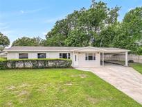 Charming single-story home featuring a lush front yard and covered carport at 1204 Marie Ave, Apopka, FL 32703