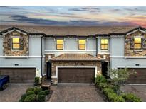 Beautiful two-story townhome features a brick-paved driveway and attached two-car garage at 1246 Payne Stewart Dr, Davenport, FL 33896