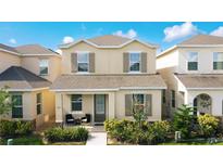 Charming two-story home featuring a cozy front porch, well-maintained landscaping, and inviting curb appeal at 129 Boydfield Ln, Davenport, FL 33837