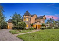 An attractive two-story home showcasing a turret and beautifully manicured front lawn at 1415 Brumley Rd, Chuluota, FL 32766