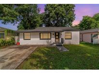 Charming single-story home featuring a well-maintained lawn and a classic design, nestled amongst mature trees at 1422 Russell Ave, Orlando, FL 32806