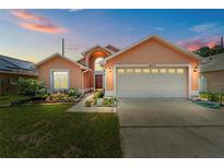 Charming single-Gathering home with a well-manicured lawn, colorful flowers, and an attached two-car garage at 1803 Tillstream Dr, Orlando, FL 32818