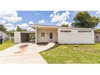 Charming single-story home with fresh exterior paint, a spacious carport, and inviting front yard landscaping at 1824 Dorris Dr, Orlando, FL 32807