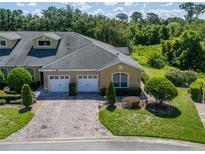 Beautiful two-story townhome with well-manicured lawn, shrubbery and brick paved driveway at 2673 Rutledge Ct, Winter Haven, FL 33884
