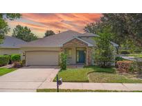 Charming single-story home with stone accents, blue door, attached garage, and manicured lawn at 413 Pursley Dr, Deland, FL 32724