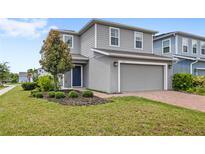 Charming two-story home featuring a well-maintained lawn, landscaping and brick-paved driveway at 4301 Creek Bank Dr, Kissimmee, FL 34744