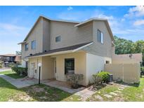 Two-story home with beige siding and a well-maintained lawn with shrubbery at 628 Olympic Dr # 8-C, Ocoee, FL 34761