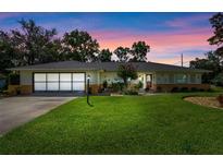 Charming single-story home with lush lawn, mature landscaping, and a two-car garage on a lovely lot at 73 Alano Rd, Debary, FL 32713