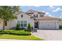 Charming two-story home featuring a tile roof, a brick paved driveway, and manicured landscaping at 7388 John Hancock Dr, Winter Garden, FL 34787