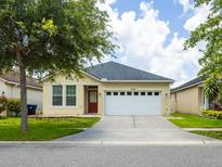 Charming single-story home with a well-manicured lawn and a two-car garage at 7557 Azalea Cove Cir, Orlando, FL 32807