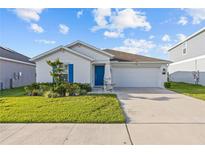 Charming single-story home with a well-manicured lawn, blue shutters, and a two-car garage at 873 Daring Dr, Davenport, FL 33837