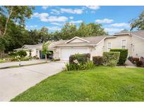 Charming single-story home featuring a well-maintained lawn, attached garage, and inviting curb appeal at 8932 Village Green Blvd, Clermont, FL 34711
