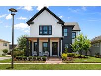 Charming two-story home with manicured lawn and inviting front porch seating at 9201 Smithies St, Orlando, FL 32827
