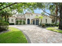 Stunning Mediterranean-style home featuring a clay tile roof and beautiful paver driveway at 9809 Covent Garden Dr # Drive, Orlando, FL 32827