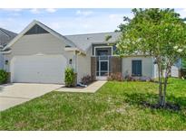 Charming single-Gathering home with an attached garage, front lawn, and beautiful landscaping at 10473 Glassborough Dr, Orlando, FL 32825