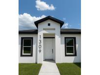 Modern home featuring a white exterior with black trim and a welcoming front entrance at 1309 Hillsborough Ln, Kissimmee, FL 34759
