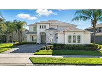 Stunning two-story home featuring stone accents, a paved driveway, and lush landscaping at 13924 Jomatt Loop, Winter Garden, FL 34787