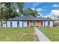 Charming single story home with a well-manicured lawn and a welcoming walkway at 1484 Lake Francis Dr, Apopka, FL 32712