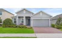 Charming single-story home featuring a well-manicured lawn, two-car garage, and inviting front porch at 2929 Bluestem Ln, Clermont, FL 34714
