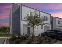 Modern two-story townhome with stone accents, manicured landscaping, and a sleek, contemporary design at 312 Famagusta Dr, Davenport, FL 33896