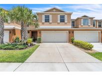 Inviting two-story townhome featuring a spacious two car garage and well-maintained landscaping at 3256 Rodrick Cir, Orlando, FL 32824