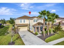 Inviting home boasts a manicured lawn, mature palm trees and neutral color scheme at 4123 Oaktree Dr, Davenport, FL 33837