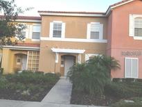 Charming townhome featuring a well-manicured lawn and lush landscaping at 4529 Alberto Cir, Kissimmee, FL 34746