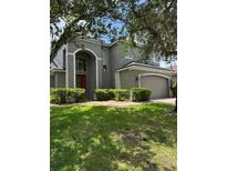 Two-story home featuring a well-maintained lawn, red front door, and a two-car garage at 5040 Rock Rose Loop, Sanford, FL 32771