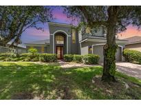 Charming gray two-story home boasts a manicured lawn and vibrant red front door at 5040 Rock Rose Loop, Sanford, FL 32771