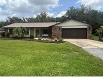 Charming single-story brick home featuring a lush green lawn and well-maintained landscaping at 5935 Sheryl Anita St, Oviedo, FL 32765