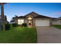 Charming single-story home with well-maintained lawn, attached garage, and appealing curb appeal at 8102 Pomo Dr, Kissimmee, FL 34747