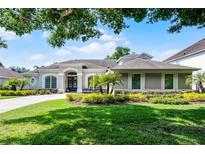 Well-manicured front exterior of a gray single-story home with a beautiful lawn and landscaping at 8122 Westminster Abbey Blvd, Orlando, FL 32835