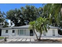 Charming single-story home with lush tropical landscaping and a beautifully paved driveway at 9148 Oakwood Dr, Lake Wales, FL 33898