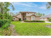 Charming two-story home featuring manicured landscaping, a grand entrance, and an inviting front yard at 9285 Wickham Way, Orlando, FL 32836