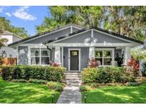 Charming single-story home featuring a landscaped yard, gray siding, and inviting front porch at 1217 Kenwood Ave, Winter Park, FL 32789