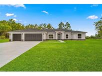 Charming single-story home with a three-car garage and a beautifully landscaped front yard at 12756 Sw 80 St, Dunnellon, FL 34432