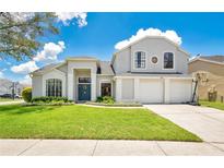 Charming two-story home featuring a well-manicured lawn, three-car garage, and inviting front entrance at 13691 Crystal River Dr, Orlando, FL 32828