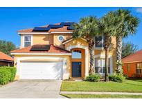 Inviting two-story home featuring an attached two car garage, solar panels and a red tiled roof at 1428 Solana Cir, Davenport, FL 33897