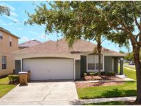 Charming single Gathering home featuring a well-maintained lawn, mature landscaping, and a two-car garage at 150 Barefoot Beach Way, Kissimmee, FL 34746