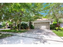 Charming single Gathering home featuring a manicured lawn, brick driveway, and attached two car garage at 1646 Song Sparrow Ct, Sanford, FL 32773