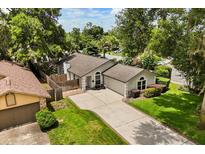 Charming single-story home with a well-manicured lawn and a long driveway in a lush, green neighborhood at 1891 Bryan Ave, Winter Park, FL 32789