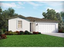 Charming single-story home featuring a two-car garage, manicured lawn and colorful flower beds at 2074 Rosewood Dr, Bartow, FL 33830