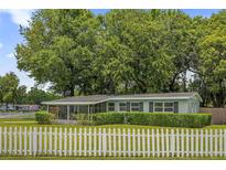 Charming single-story home with a white picket fence and well-manicured landscaping at 224 Woodmere Blvd, Sanford, FL 32773