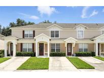 Inviting townhome featuring a well-manicured lawn and charming architectural details at 2409 Silver Palm Dr, Kissimmee, FL 34747