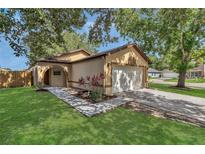 Charming single-Gathering home with lush front lawn, mature trees, and two car garage at 2935 Canoe Cir, St Cloud, FL 34772